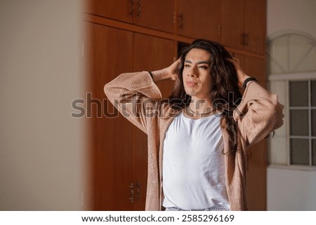 Non-binary person getting dressed in front of the mirror