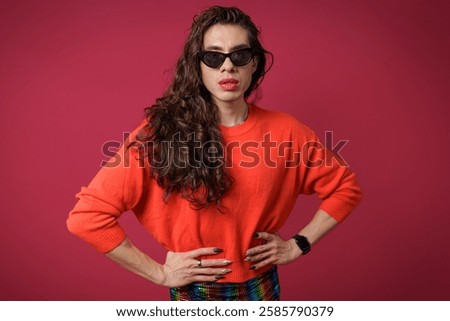 non-binary person is posing on a red studio background Man has an artistic expression. Concept of non-binary people. pride