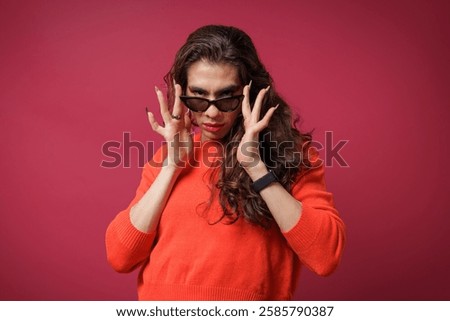 non-binary person is posing on a red studio background Man has an artistic expression. Concept of non-binary people. pride