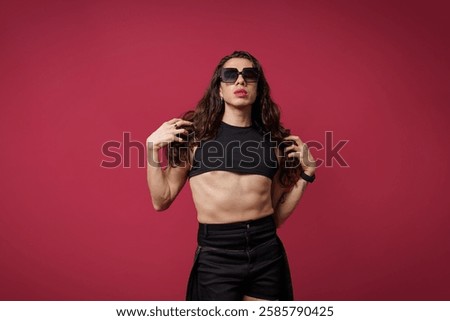 non-binary person is posing on a red studio background Man has an artistic expression. Concept of non-binary people. pride