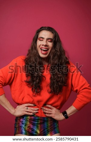 non-binary person is posing on a red studio background Man has an artistic expression. Concept of non-binary people. pride