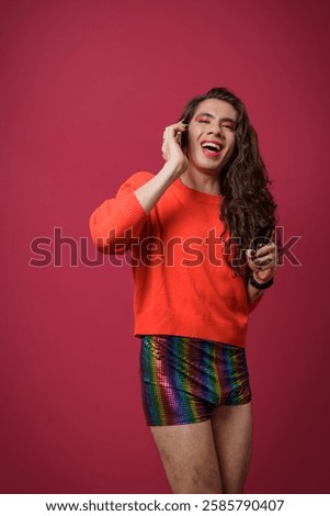 Non-binary person talking on cell phone with a happy expression on their face