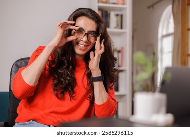 Non-binary person working with a big smile while adjusting their glasses