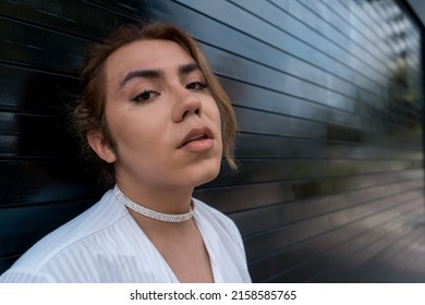 non-binary using phone in her hands chating leaning on black gate in the street remembering - Powered by Shutterstock