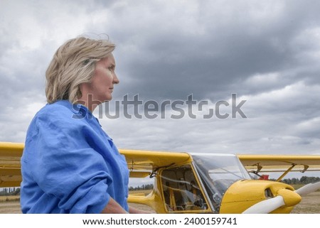 Non-flying weather. A woman on the runway against the backdrop of an airplane. overcast clouds Stock photo © 