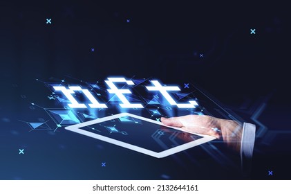 Non-fungible token hologram on virtual digital screen of tablet device holding by businessman, nft with network circuit. Dark background. Concept of cryptoart and technology