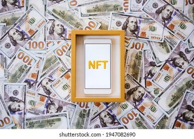 Non-fungible Token NFT, Crypto Art, Digital Art, New Type Of Cryptorurrency. Cell Phone With Golden NFT Text In Golden Frame As Art Object On Dollars Background