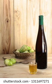 Noni Juice Bottle With Noni Fruit Basket On Wooden Table..jpg