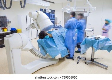 A non-invasive surgery in modern hospital while patient being scanned with C-arm X-ray. - Powered by Shutterstock