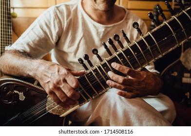 Non-recognisable musician playing sitar, traditional indian musical instrument, close up photo of hands. Indian folk music concept.