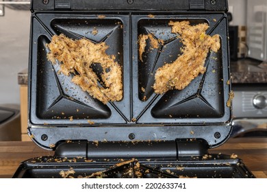 Non-stick Coating Failure. Sandwich Toaster Disaster With Stuck Food Burnt On. Close-up Of Gadget Cooking Mess As Non Stick Coating Fails. And Dirty Bread Needs To Be Cleaned Up. 
