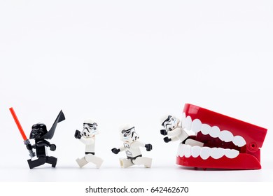 Nonthabure, Thailand - May, 17, 2017 : Red Plastic chattering teeth being bitten Lego Darth Vader and Lego stormtrooper isolated on white background.