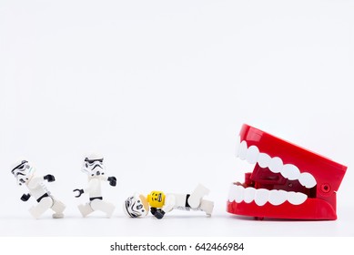 Nonthabure, Thailand - May, 17, 2017 : Red Plastic chattering teeth being bitten Lego Darth Vader and Lego stormtrooper isolated on white background.