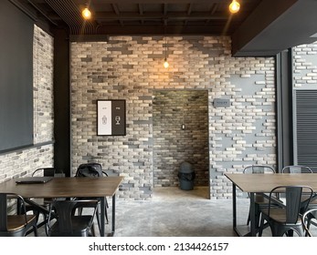 Nonthaburi, Thailand; 11 March 2022:  Modern cafe interior with a brick wall, a wooden tables. The interior design of a Coffee shop, cafe.