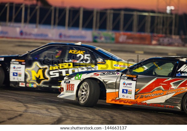 NONTHABURI THAILAND-JUNE 30 :\
Battle lap of two drift drivers at night time in D1 Grand Prix\
Series Thailand Professional Drift on June 30, 2013 in Nonthaburi,\
Thailand.