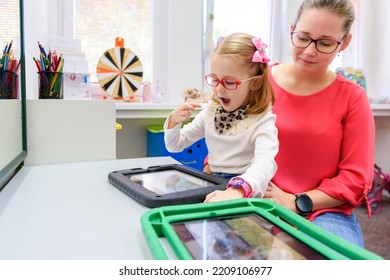 Non-verbal Girl Living With Cerebral Palsy, Learning To Use Digital Tablet Device To Communicate. People Who Have Difficulty Developing Language Or Using Speech Use Speech-generating Devices.