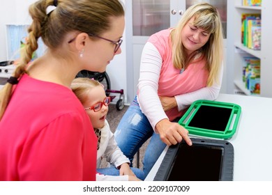 Non-verbal Girl Living With Cerebral Palsy, Learning To Use Digital Tablet Device To Communicate. People Who Have Difficulty Developing Language Or Using Speech Use Speech-generating Devices.