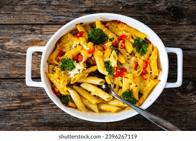 Noodle casserole with mozzarella cheese and vegetables on wooden table
 - Shutterstock ID 2396267119
