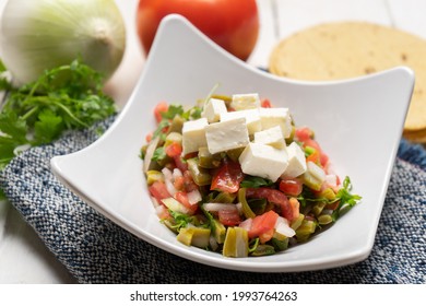 Nopal cactus salad with cheese on white background. Traditional mexican food