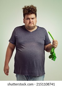 Nope, Dont Want It. Shot Of An Unhappy Overweight Man Holding A Celery Stick.