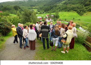 NORDDAL - JUNE 26: Russian tourists stand on hill and listen guide on JUNE 26, 2011 in Norddal, Norway. In 2011 Norway issued to Russian citizens 30 236 visas, 65% of visas were tourist.