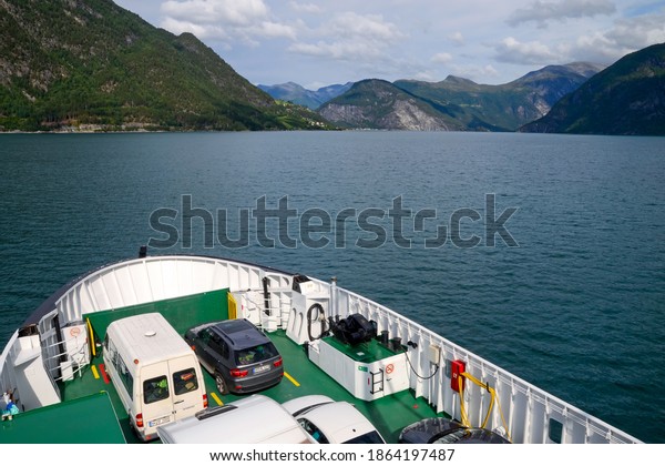 Norddalsfjord,\
Norway - August, 2014: Infrastructure of the country. Ferry with\
cars on it floats from Eidsdal to\
Linge.