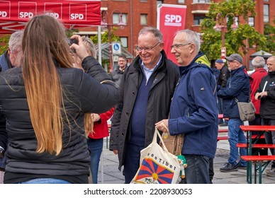 Nordenham, Germany - October 01, 2022: Stephan Weil, Prime Minister Of Lower Saxony, Stands On The Market Square Next To A Man, A Woman Takes A Photo Of Them 