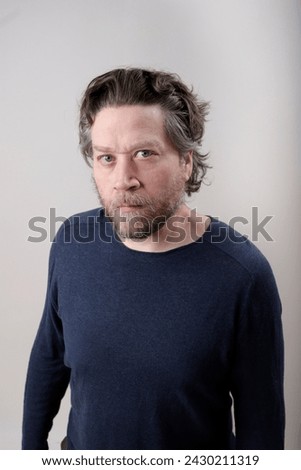 nordic man swooping down looking at camera seriously on light background