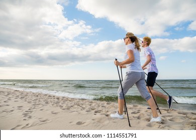 Nordic Walking - Man And Woman Training On Beach 