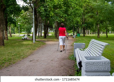 Nordic Walking - Middle-aged Woman Working Out In City Park