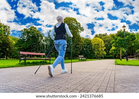 Nordic walking - woman exercising in city park 