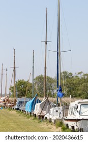 Norfolk Broads. Moored Sailing Boats. Yachts Along The River Bank In Norfolk, East Anglia UK.