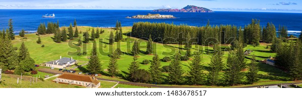Norfolk Island,\
South Pacific, Australia. \
Norfolk Island golf course lined with\
norfolk island pines.\
In the foreground are buildimgs from the\
convict period of the\
1820\'s.