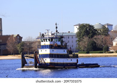 Norfolk, VA, USA - December 26, 2021: A Tugboat Moves Along The Elizabeth River With The City Of Portsmouth In The Background.