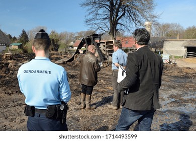 Normandy, France, April 2014.
Arson Attack In A Farm. Farm Building And Farm Equipment Calcined. Rubble On The Ground . First Observation Of The Police And The Adjuster Investigator With The Farmer