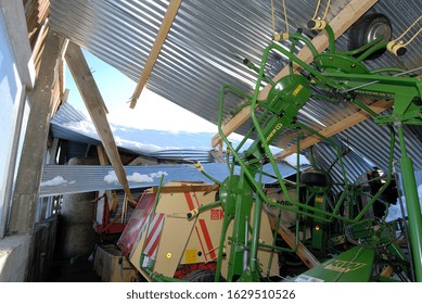 Normandy, France, January 2010.
Roof Collapsed Of A Farm Building Under The Weight Of The Snow Due Tot Heavy Snowfall During Storm Winter. Damaged Agricultural Equipment. Massive Storm Damage