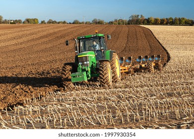 Normandy, France, November 2005. Autumn Plowing On A Cornfield. Winter Wheat Planting With Simultaneous Soil Tillage. Church In The Background