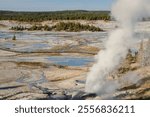 Norris Geyser Basin in Yellowstone features vibrant hot springs, fumaroles, and the world’s tallest geyser, Steamboat, in a geologically active area.