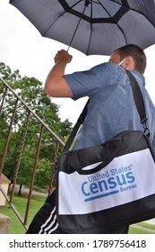 Norristown, PA/USA-August 4, 2020:  Young Enumerator Census Taker Door Knocker Climbs Steps With Umbrella Over His Head, Wearing Mask With No Face Showing.