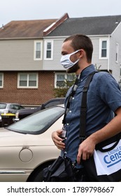 Norristown, PA/USA-August 4, 2020:  Young Man Working Door To Door For The Census, Wears A Mask And Walks The Neighborhood Carrying His Laptop Bag, Cell Phone And Wearing His Badge, Ready To Count 