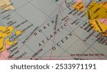 North Atlantic Ocean region, location or territory mark drawing on a map with some famous country names words or text written on the surface. Closeup top view. Sea adventure or navigation concept.