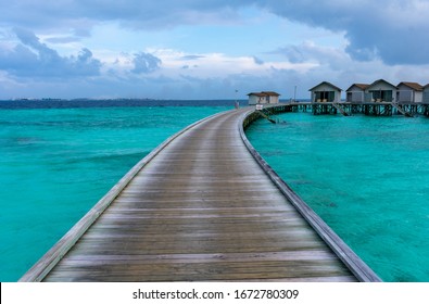 North Malé Atoll, Maldives - December 29 2019 - A Wooden Pier Towards The Water Villas