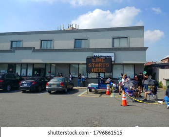 North Bergen, NJ - July 25 2020: Visitors to the New Jersey Motor Vehicle Commission offices queued outside in the parking lot during the coronavirus pandemic