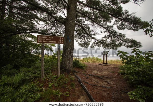 North Country Trail On Lake\
Superior Coast. Mile marker and blue blaze for the North Country\
along the Lake Superior coast in the Upper Peninsula of\
Michigan.