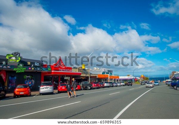 NORTH ISLAND, NEW ZEALAND-\
MAY 18, 2017: Taupo is a town on the shore of Lake Taupo in the\
centre of the North Island of New Zealand. Some cars parked outside\
of a store