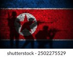 North korea flag on brick wall and soldiers shadow