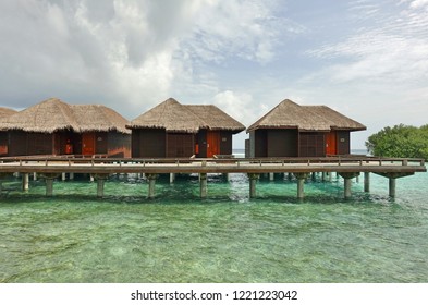 NORTH MALE, MALDIVES -6 JUL 2018- View of expensive luxury over the water bungalows with thatched roofs at the Sheraton Maldives Full Moon Resort & Spa hotel on Furanafushi Island, North Malé Atol.