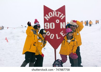 North Pole - 15 July 2016: Best Arctic Journey. Entertainment Tourists. Pointer Of Geographical North Pole Poit Where All Longitude And 90 Degrees Latitude. Chinese Tourist Takes Picture