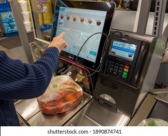 NORTH PORT, FLORIDA - January 10, 2021 : Female Shopper Using Self Service Checkout At Grocery Store. Customer Scanning Produce Items Using Supermarket Self Serve Cash Register.