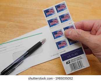 NORTH PORT, FLORIDA - June 3, 2021: Book Of First Class U.S. Flag Forever Stamps. Hand Holding Postage For Mailing A Letter Via The United States Postal Service.